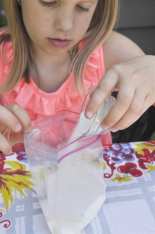 ice-cream-in-a-bag A girl in a pink blouse making ice cream in a Ziploc bag