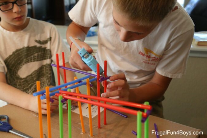 STEM-challenge Boys building roller coaster from Tinker Toys as an example of fun last day of school activities