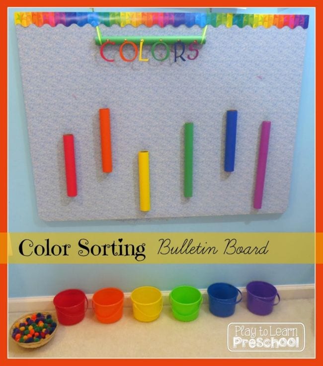 Interactive Bulletin Boards Play to Learn Preschool Color sorting bulletin board with colored cardboard tubes attached vertically and pom poms to drop through into buckets below