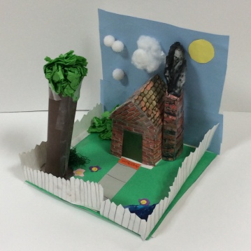 notabox A cottage scene sculpture is shown. (second grade art)