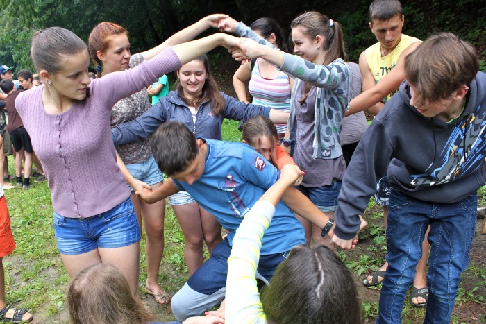 human-knot-game Teens outdoors playing the human knot game