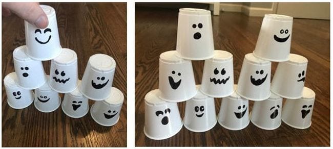 stacked-cup-ghosts Small white plastic cups with spooky faces stacked into a pyramid