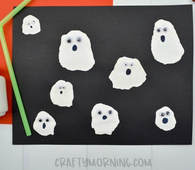 blow-paint-ghosts A black piece of construction paper with white ghosts painted on it