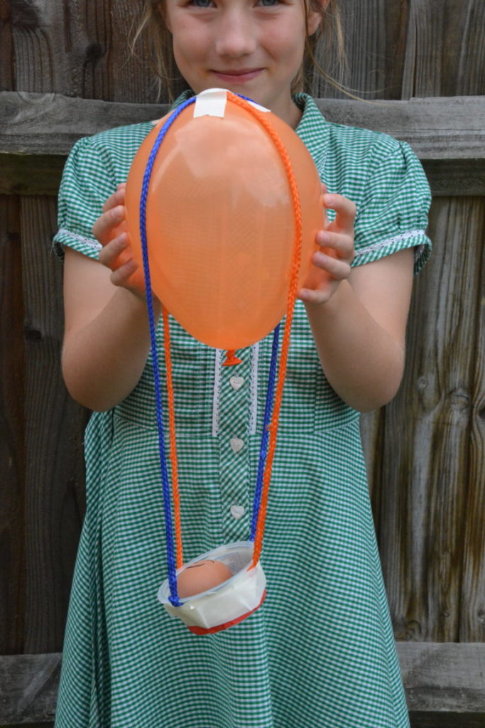 air-balloon-egg-drop girl holding a basket attached to a balloon for an egg drop
