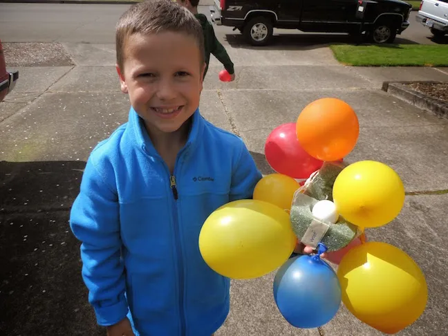balloon-bomb-egg-drop child holding an egg drop challenge, a foam surrounded by balloons