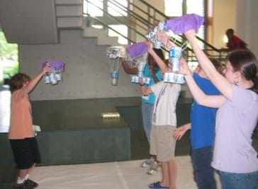 disaster-egg-drop students standing to drop eggs during an egg drop challenge
