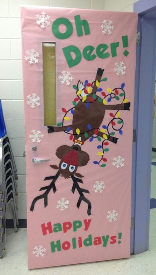 Winter Classroom Doors: Oh Deer A pink classroom door says Oh Deer! and features a reindeer with a red nose hanging upside down.