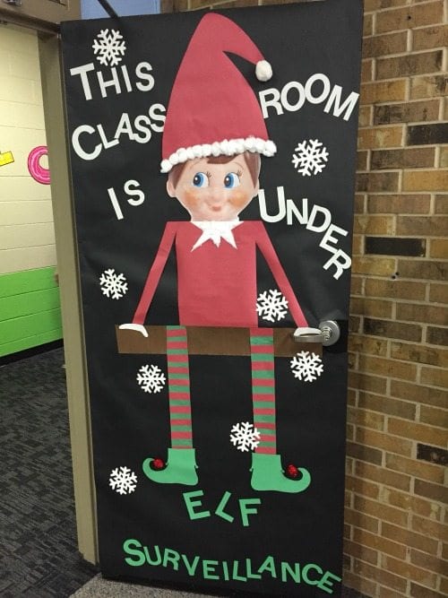 Winter Classroom Doors: Elf on the Shelf Holiday classroom doors include this one decorated with a large image of an Elf on the Shelf, with text reading This classroom is under elf surveillance