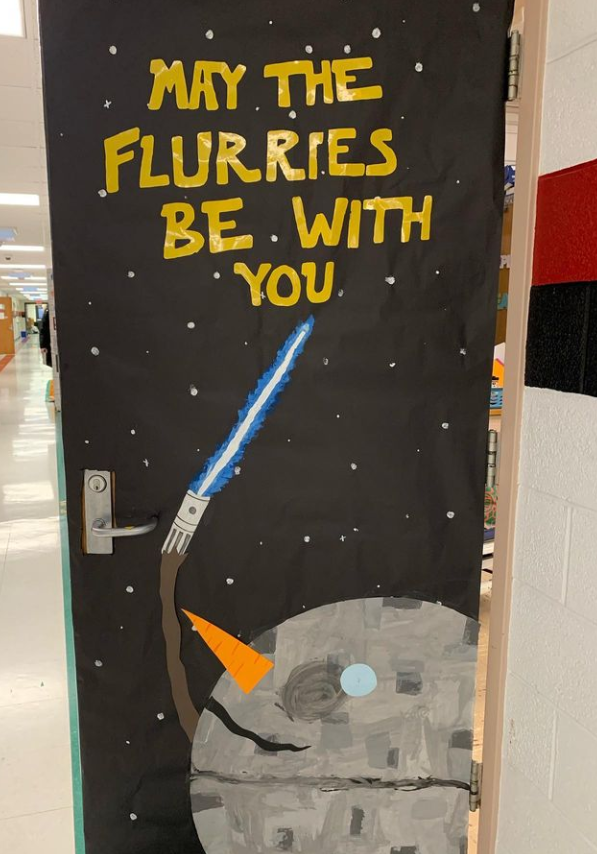 Winter Classroom Doors: Star Wars A snowman head designed to look like a robot is holding a lightsaber on a door. Text reads May the flurries be with you