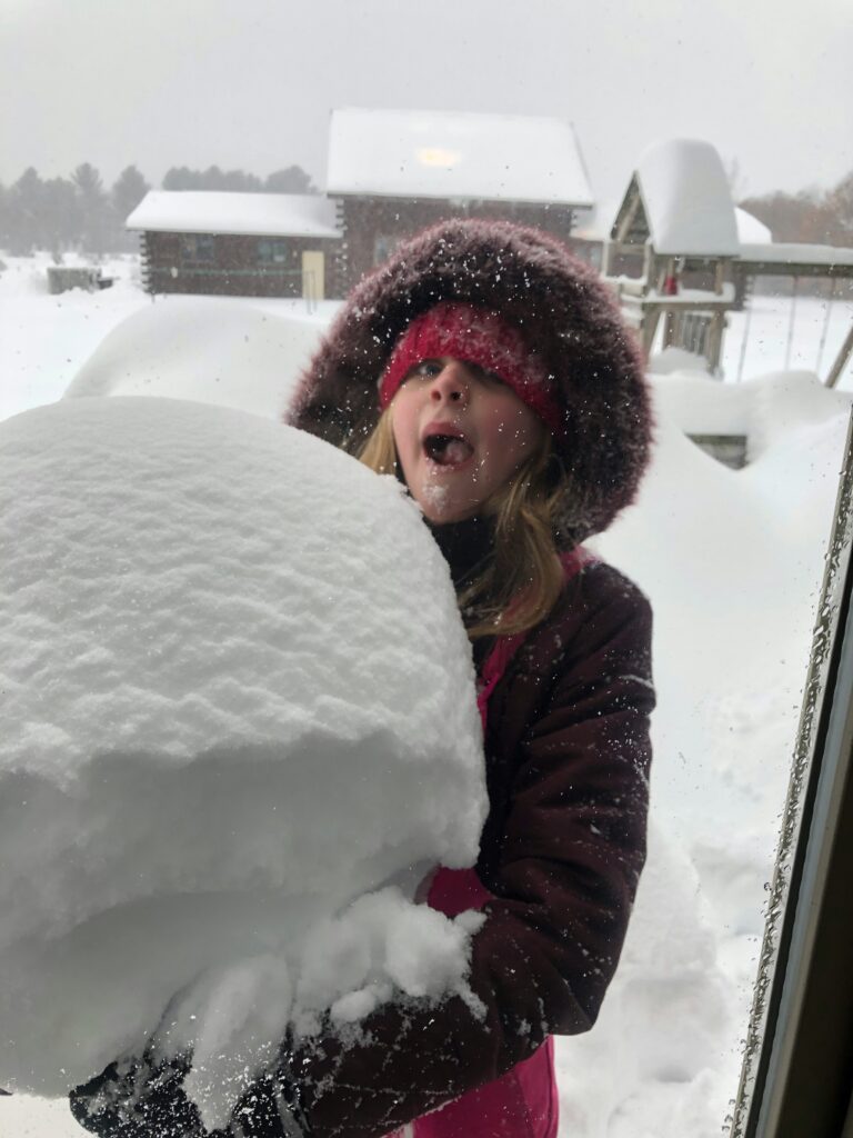 Child eating snow Child with mouth open about to eat a snowball