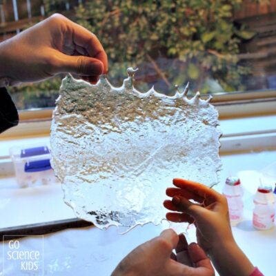 Homemade Edible Glass Experiment Child's hands holding a sheet of edible "glass" made of sugar