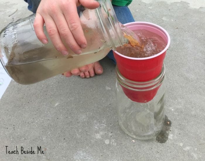 Third Grade Science Filtration Teach Beside Me Science student pouring dirty water through a plastic cup into a jar below