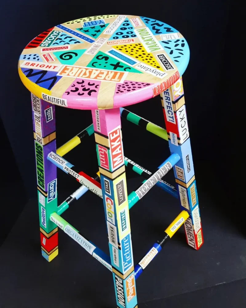 decoupaged-stool A wooden stool decoupaged with words cut from magazines and Sharpie accents as an example of school auction art projects