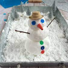 fake-snow snowman in a bin of fake snow for a snow activity