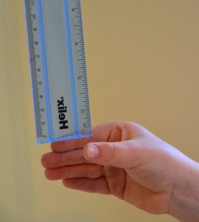 First Grade Science Experiments Blue ruler dropping into student's hand