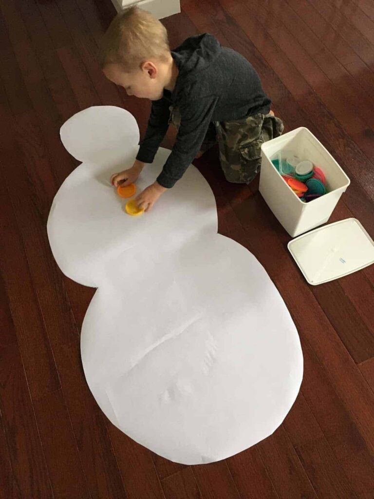 giant-snowman-buddy boy making a giant paper snowman