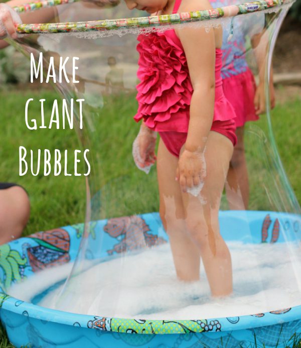 Giant Bubble Science Experiment A little girl is standing in a kiddie pool. A hula hoop surrounds her and a giant bubble. (preschool science)