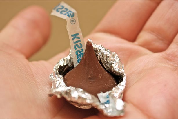 Hershey Kiss experiment Picture of a child holding a Hershey kiss candy in the palm of her hand, as an example of second grade science experiments.