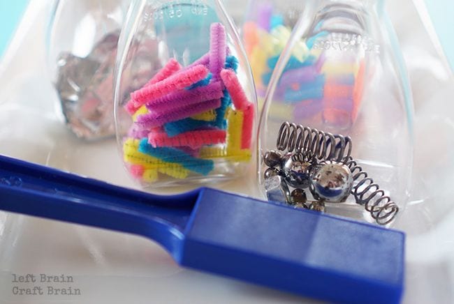 Kindergarten Science Activities Magnet Bottles Plastic bottles filled with pipe cleaners and metal springs with a large blue mar magnet (Kindergarten Science)