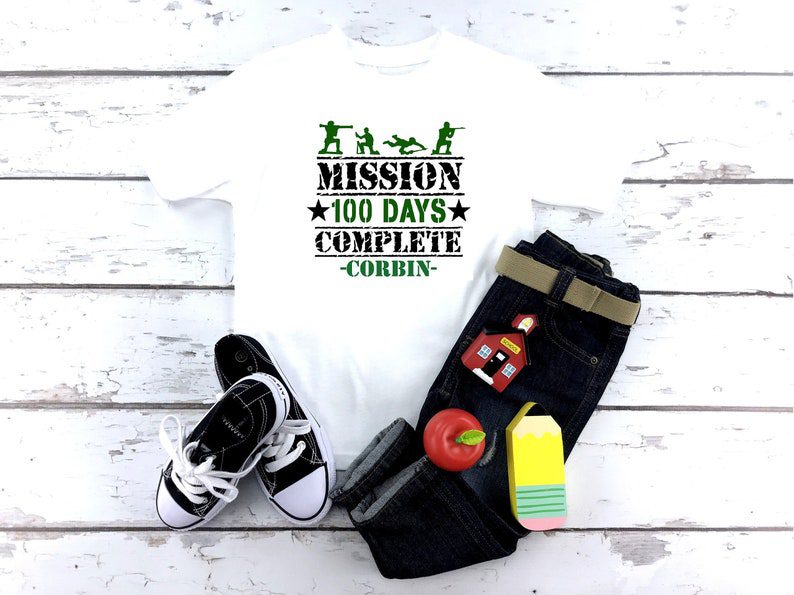 100th Day Shirt: Mission A white shirt says Mission 100 Days Complete with the name Corbin on it