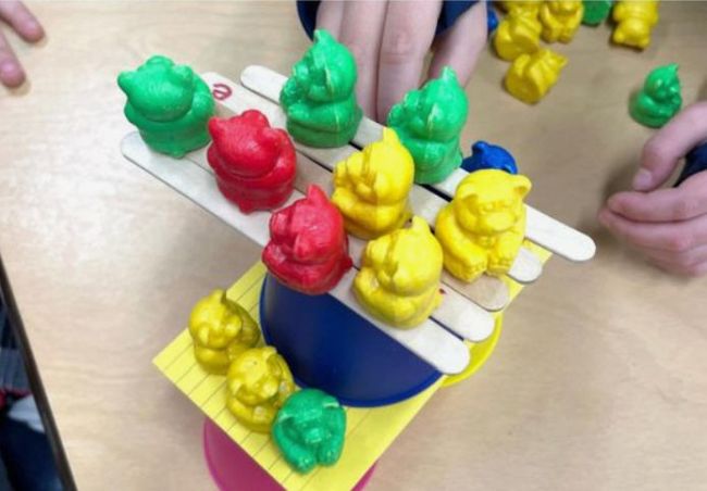 Floor is Lava STEM challenge Toy bears stacked on plastic cups, wood craft sticks, and index cards