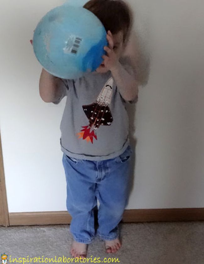 Preschool Science: Gravity Toddler holding a blue rubber ball