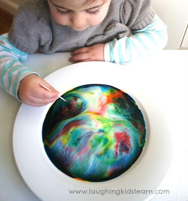 Magic Milk Preschool science student mixing a bowl of colorful milk swirls