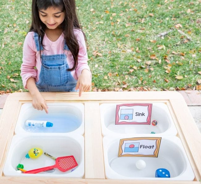 Preschool Science Sink or Float Preschool science student placing objects in bins of water to see if they sink or float