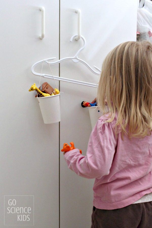 DIY Hanger Sale A little girl filling a cup in a homemade scale.