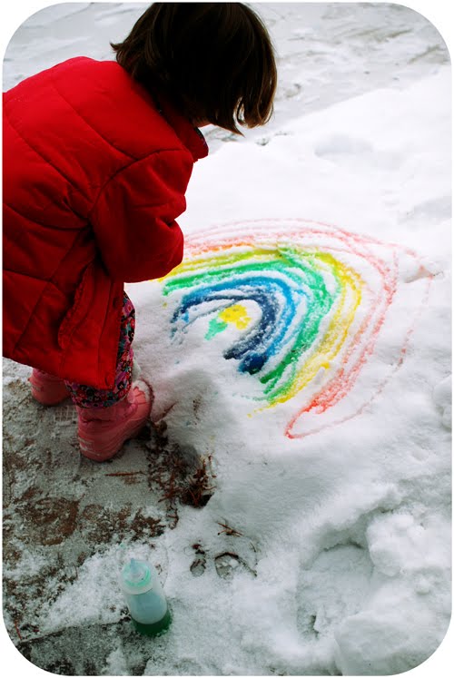 snow-painting girl using a spray bottle and coloring to paint snow