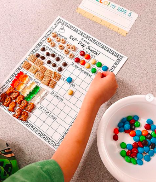 100-snacks A student fill a hundreds chart with various snacks