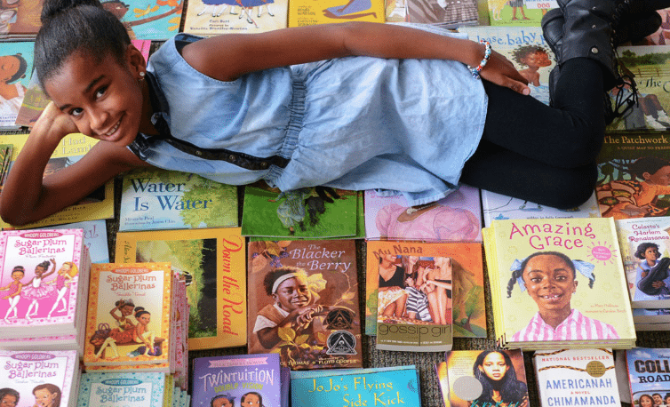 Marley Dias Marley Dias lying atop books with Black female characters
