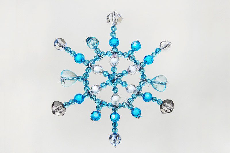 First Grade Art Projects: Beaded Snowflake A snowflake is shown that has been created using pipe cleaners and different blue and clear beads.