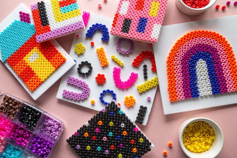 Third Grade Art Projects: Beads an assortment of beads is shown and a rainbow on a piece of paper created from them.