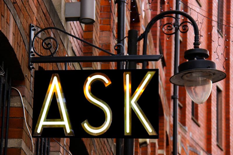 Picture Prompts: Ask Sign Lighted sign reading ASK hanging from a building