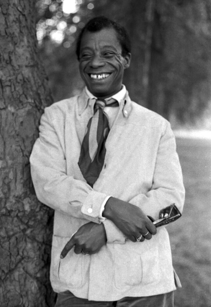 35 Famous Black Americans Everyone Should Know James Baldwin portrait outdoors by a tree