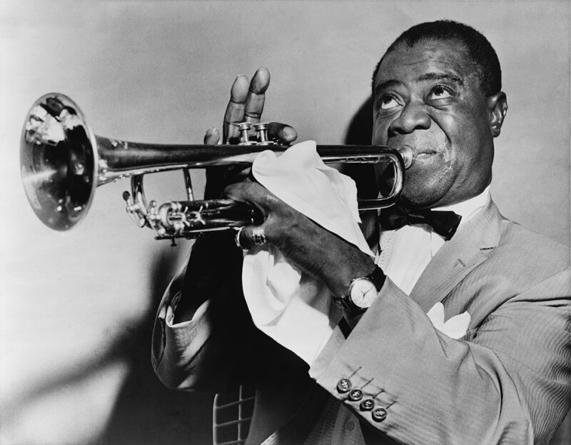 35 Famous Black Americans Everyone Should Know Black and white portrait of Louis Armstrong, one of the most famous Black Americans
