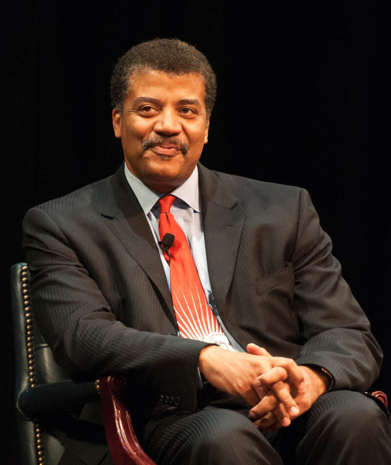 35 Famous Black Americans Everyone Should Know Neil deGrasse Tyson sitting in a chair on stage
