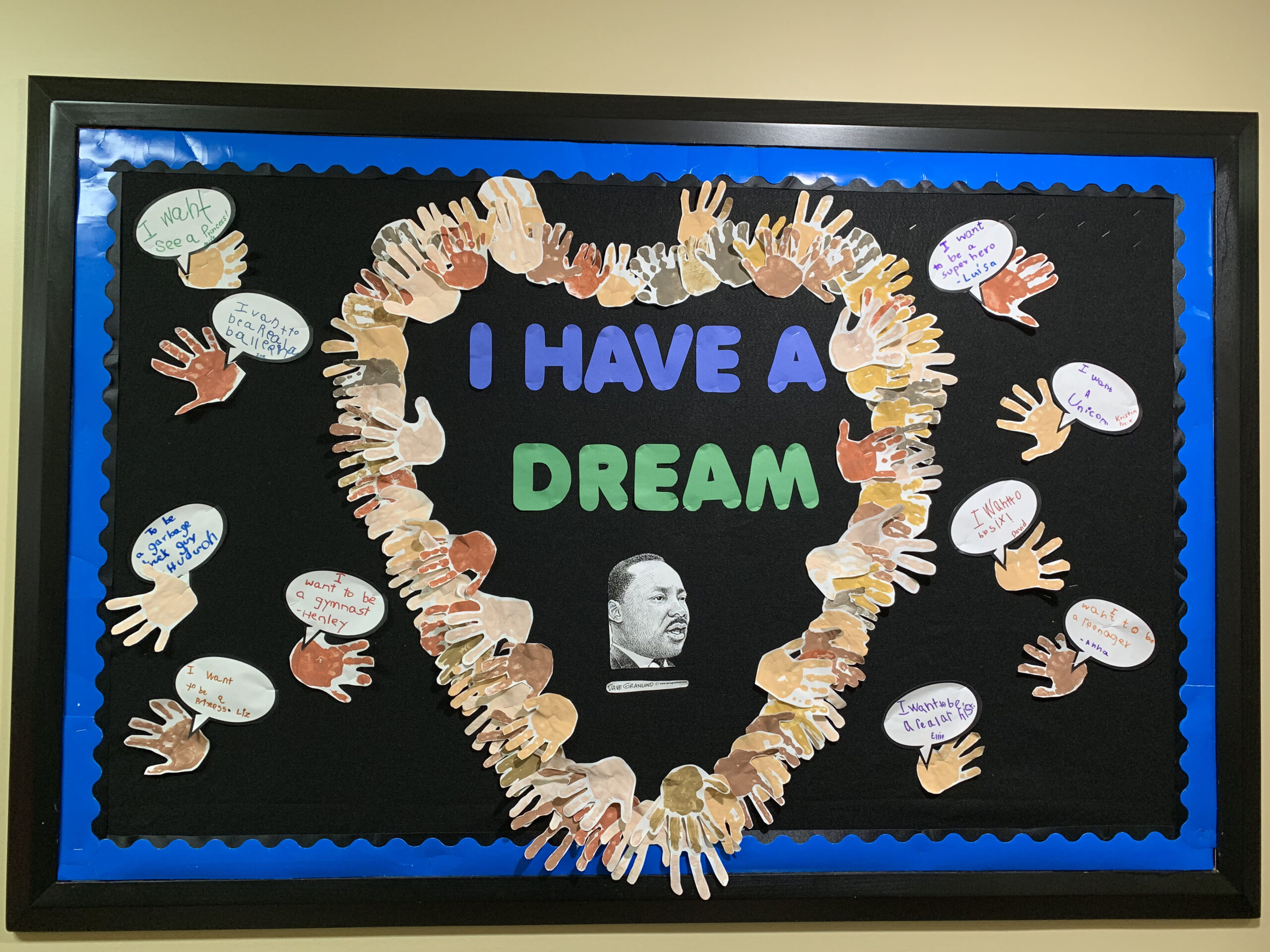 Black History Month Bulletin Board – Martin Luther King Text on a black background reads I have a dream. there is a photo of Martin Luther King Jr. and hand cutouts that form a heart around the photo (black history month bulletin board)