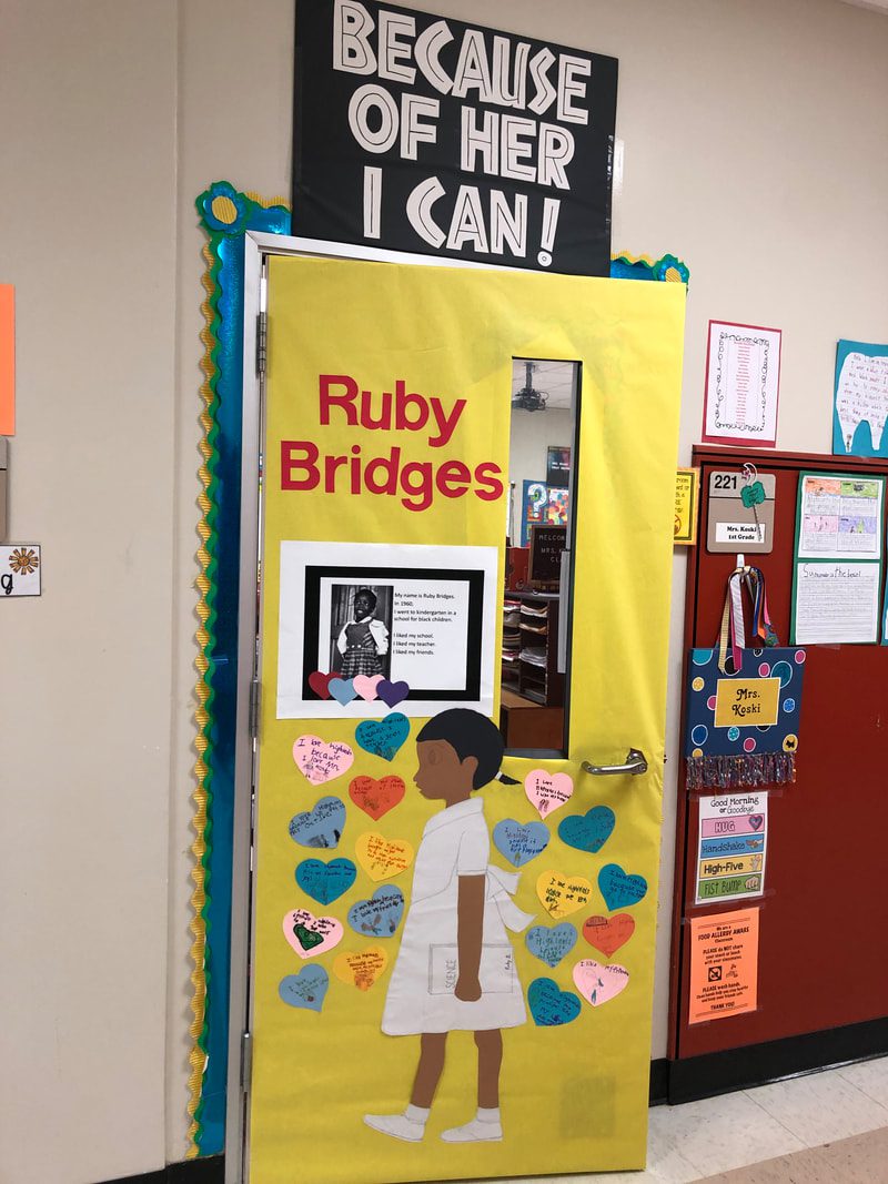 Black History Month Bulletin Board – Ruby Bridges A door says Ruby Bridges and includes a photograph of her. Most of the door is covered in hearts and a side cut out of a little girl meant to be Bridges (black history month bulletin board)