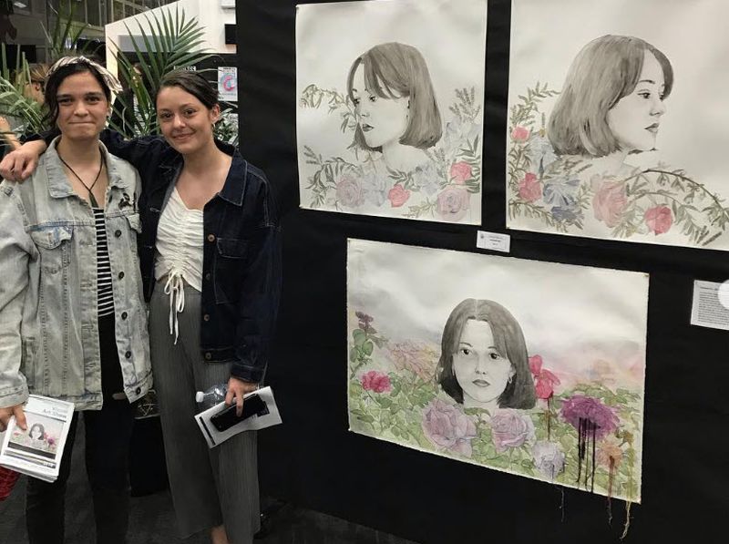 Art Show Student and parent standing by artwork at an art show