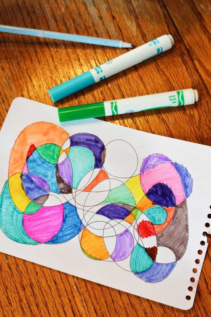Scribble Art A piece of paper has intertwining circles that are colored with markers.