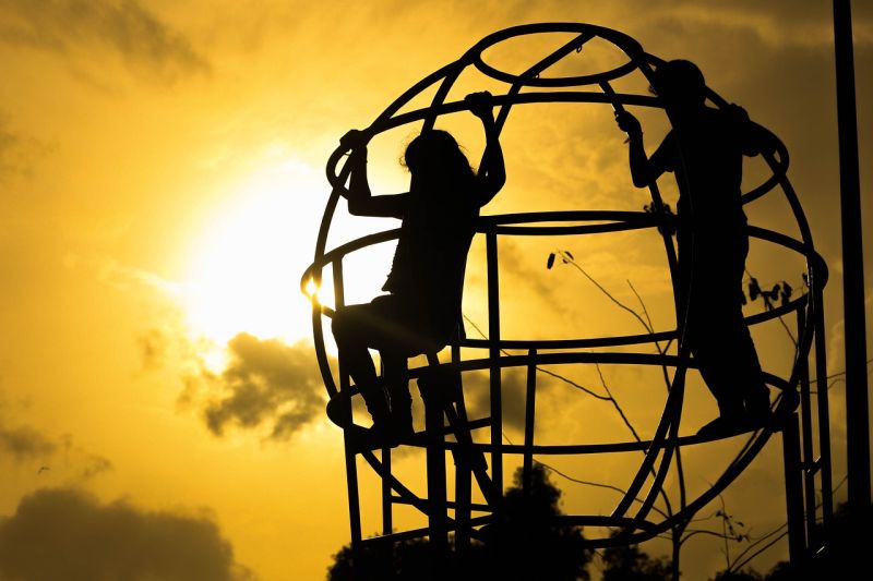 Picture Prompt: Sunset Playground Two children on a jungle gym silhouetted against a setting sun