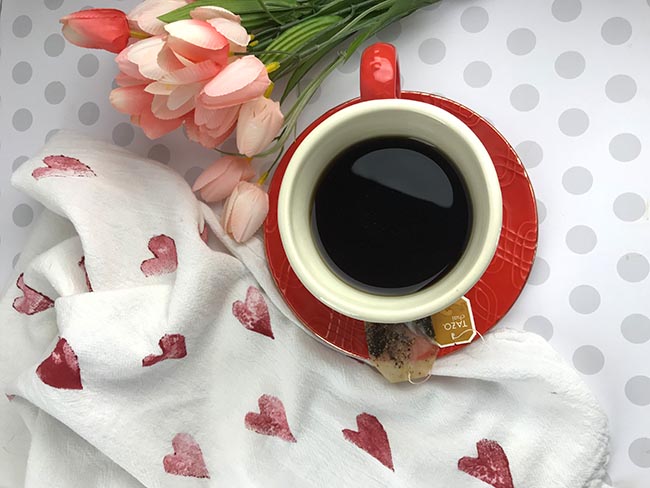 valentine-tea-towe tea towel decorated with heart stamps and a cup of tea