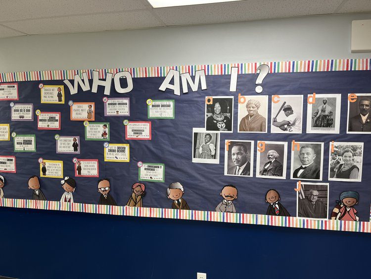 Black History Bulletin Baord – Who Am I A bulletin board has boxes with text on them on the left side and pictures on the right side. The text on the top says Who Am I?