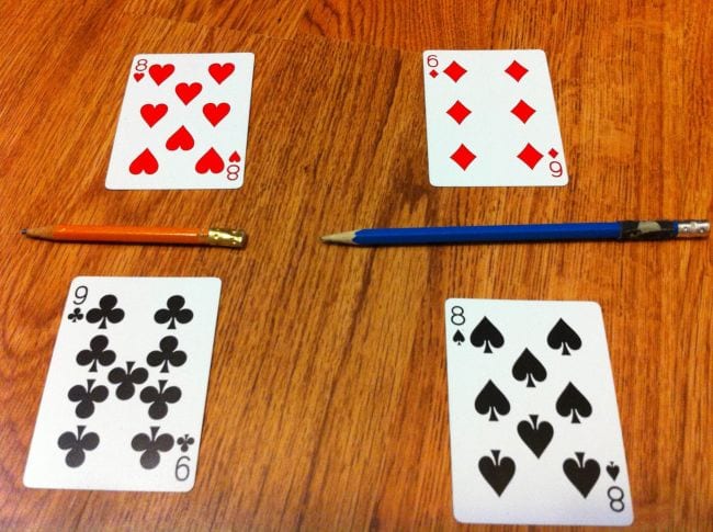 fraction-war Fractions are created with two playing cards placed on a table, one on top of the other, with a pencil in between as an example of fraction games and activities