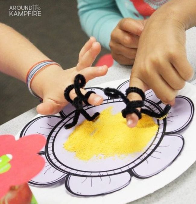 Plant Life Cycle Cheese Powder Pollinators Students wearing pipe cleaner bees on their fingers over a plate of cheese powder