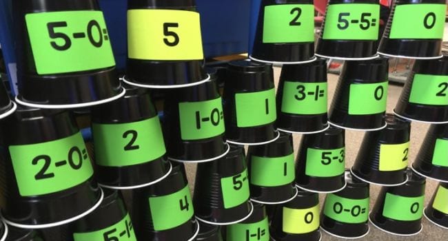 stack-cup-subtraction Black plastic cups with math problems written on them stacked up