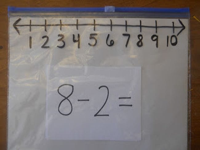 number-line-bag A ziploc bag with a number line drawn at the top in sharpie with a subtraction problem written on an index card inside the bag