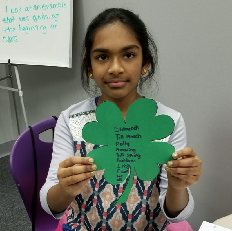 acrostic-poetry student holding an acrostic poem for a st patrick's day activity